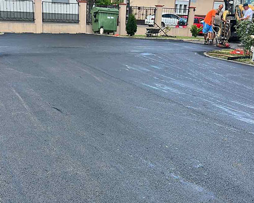 Frissen aszfaltozott parkoló társasház előtt