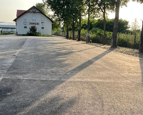 Aszfaltozott telephelyi udvar épület előtt